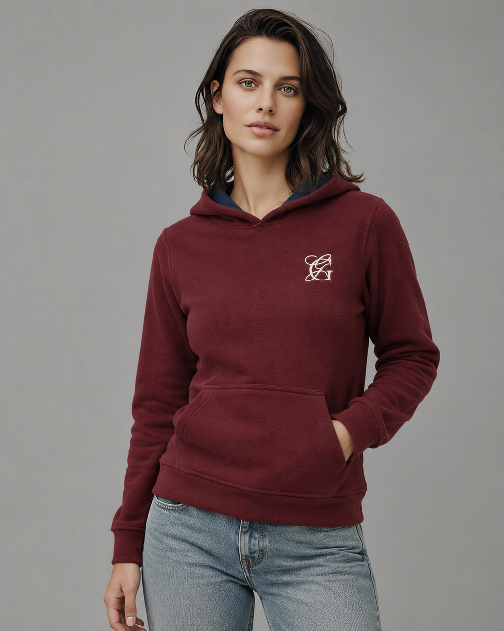 Sudadera polar Básica Dama bordada con manga larga, capucha ajustable y bolsa frontal.