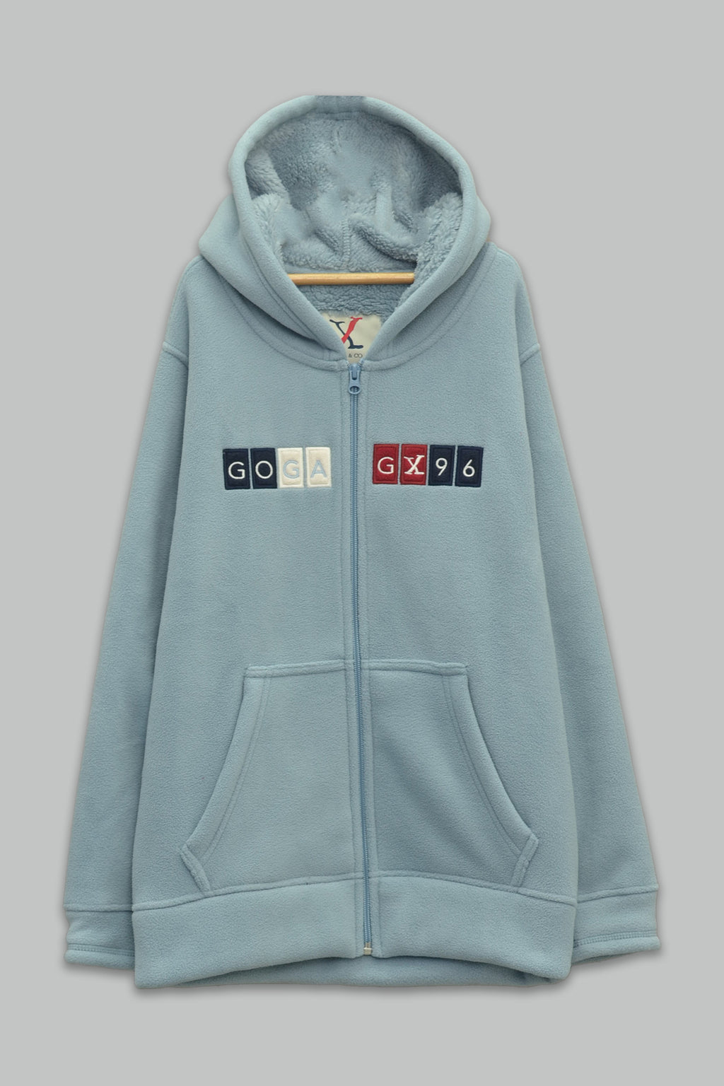 Sudadera sherpa niño bordada con manga larga, capucha ajustable, bolsas frontales y cierre.