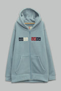 Sudadera sherpa niño bordada con manga larga, capucha ajustable, bolsas frontales y cierre.