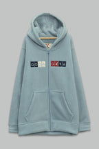 Sudadera sherpa niño bordada con manga larga, capucha ajustable, bolsas frontales y cierre.