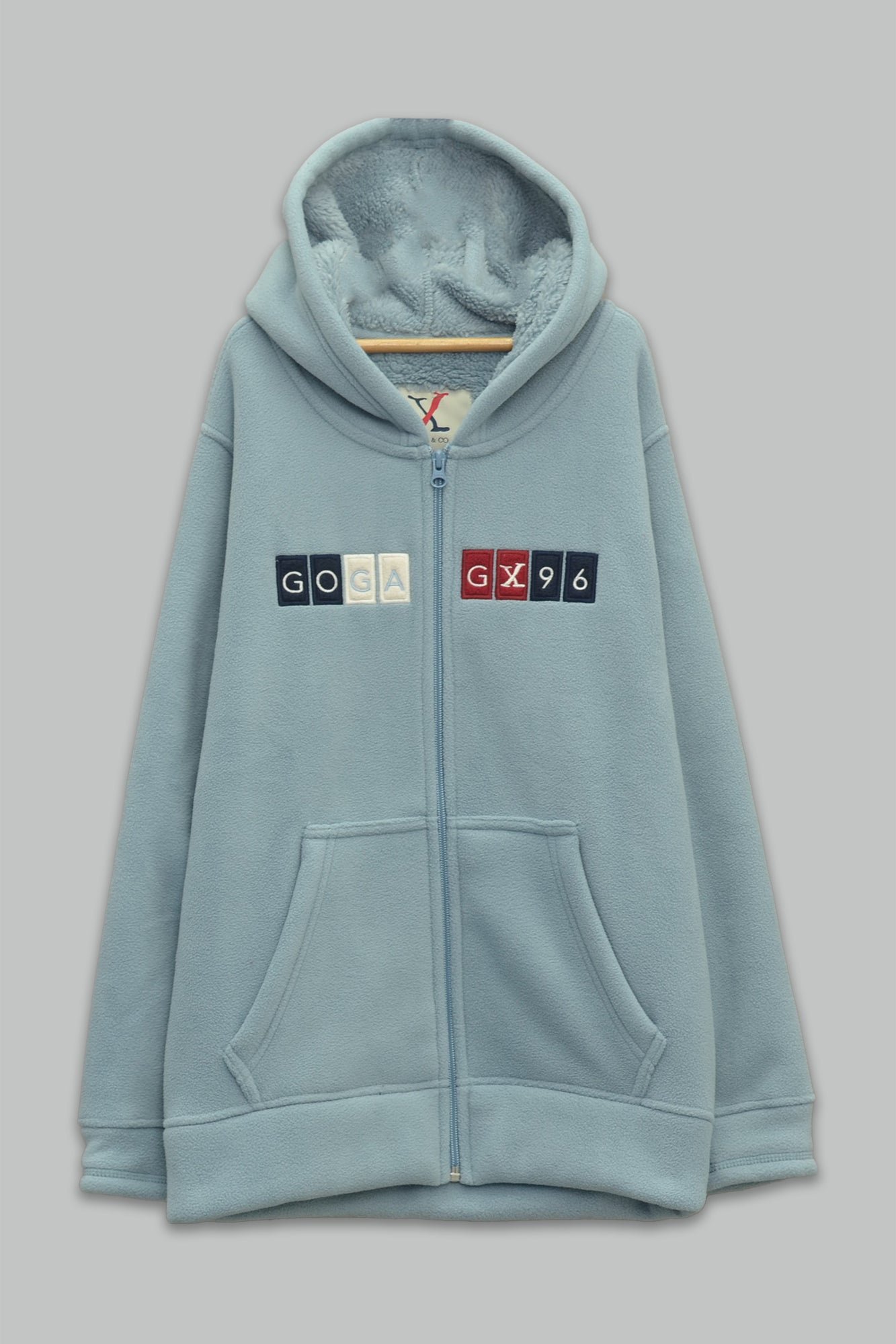 Sudadera sherpa niño bordada con manga larga, capucha ajustable, bolsas frontales y cierre.