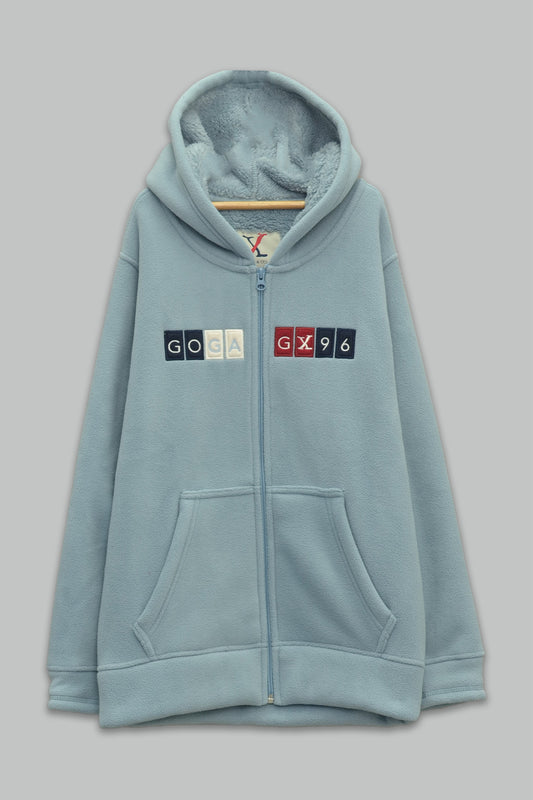 Sudadera sherpa niño bordada con manga larga, capucha ajustable, bolsas frontales y cierre.