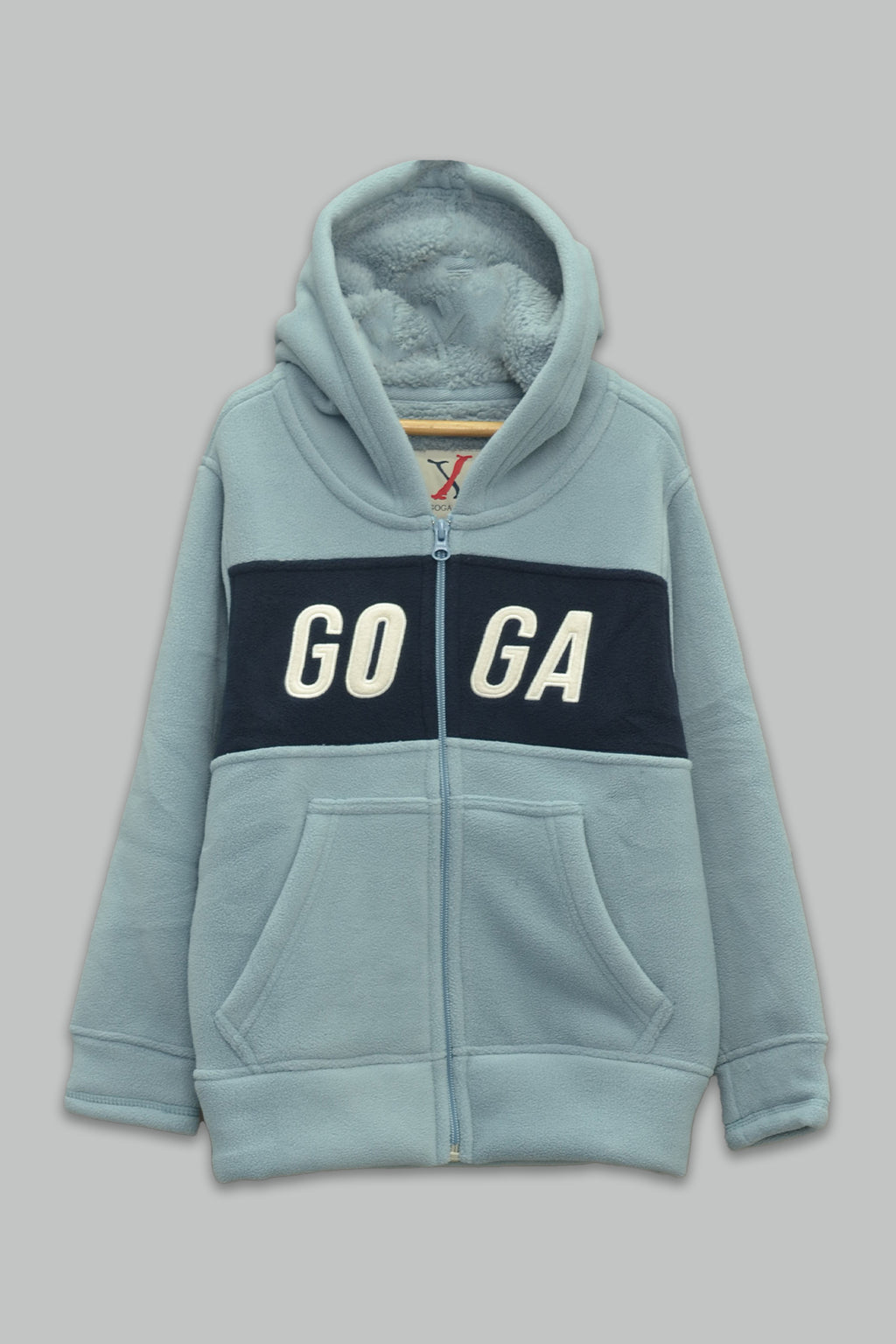 Sudadera sherpa niño bordada con manga larga, capucha ajustable, bolsas frontales y cierre.