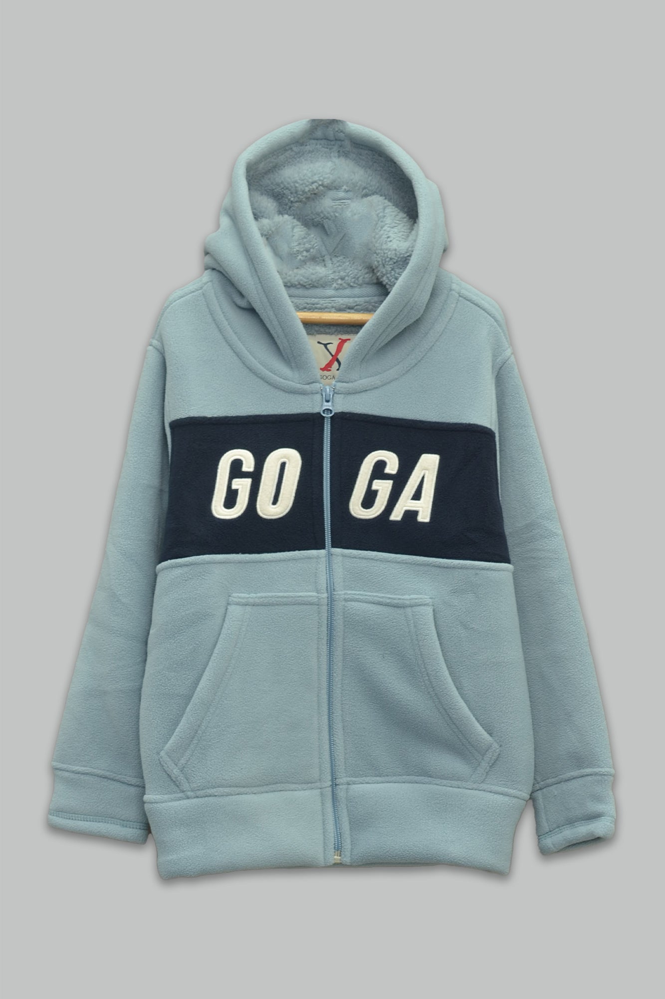 Sudadera sherpa niño bordada con manga larga, capucha ajustable, bolsas frontales y cierre.