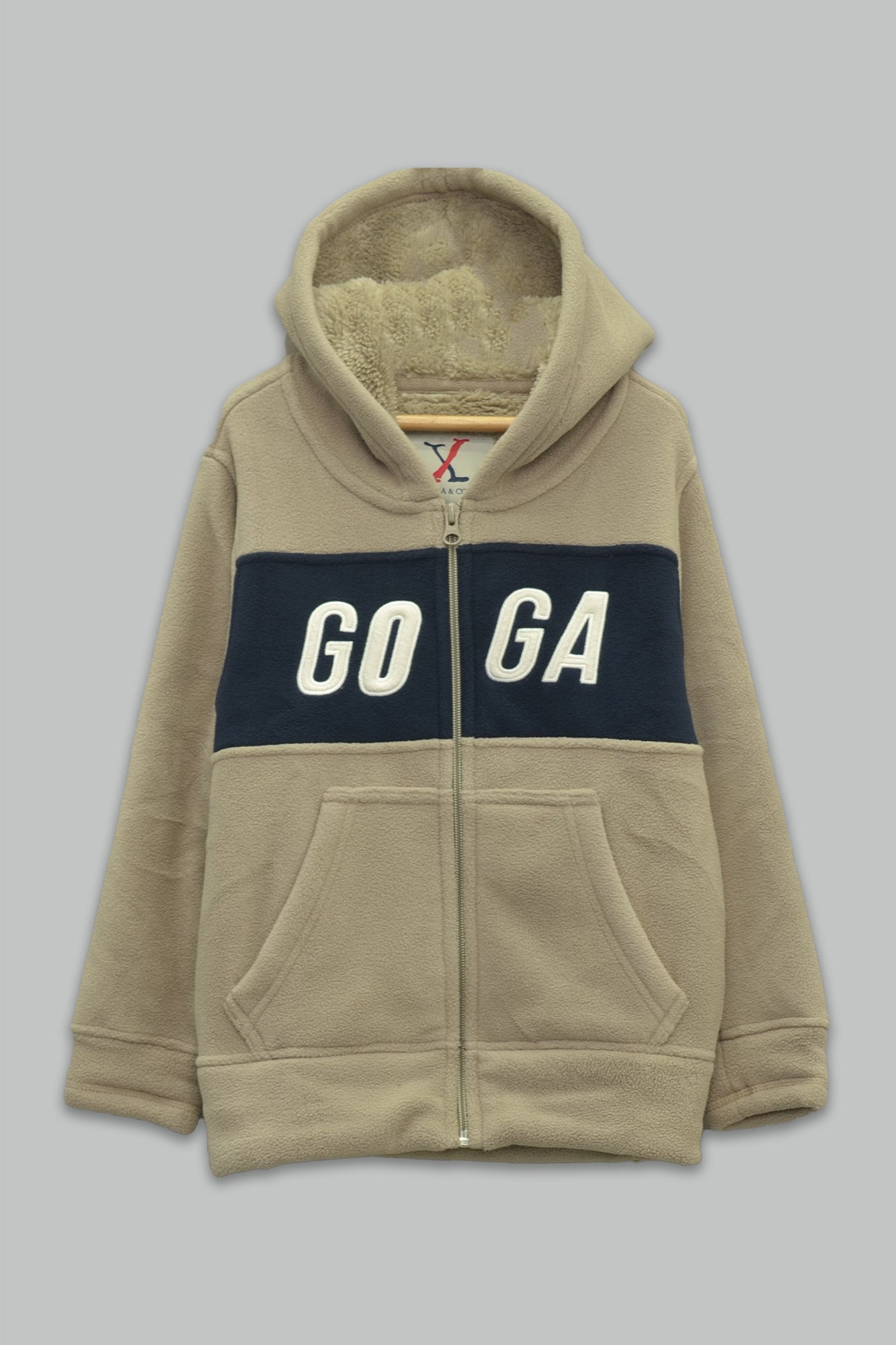 Sudadera sherpa niño bordada con manga larga, capucha ajustable, bolsas frontales y cierre.