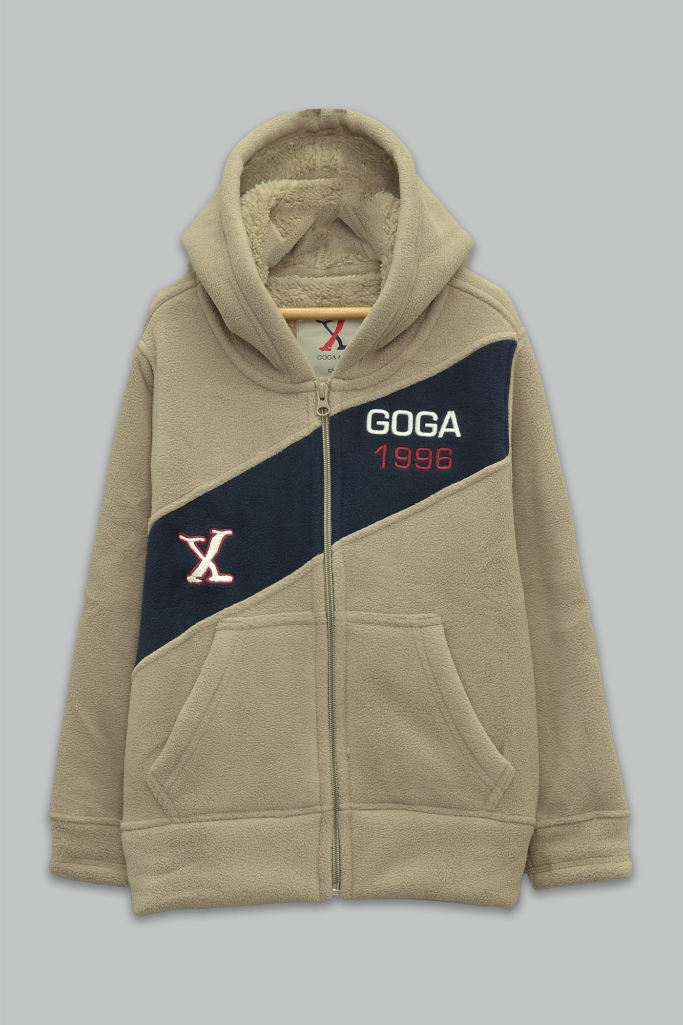 Sudadera sherpa niño bordada con manga larga, capucha ajustable, bolsas frontales y cierre.