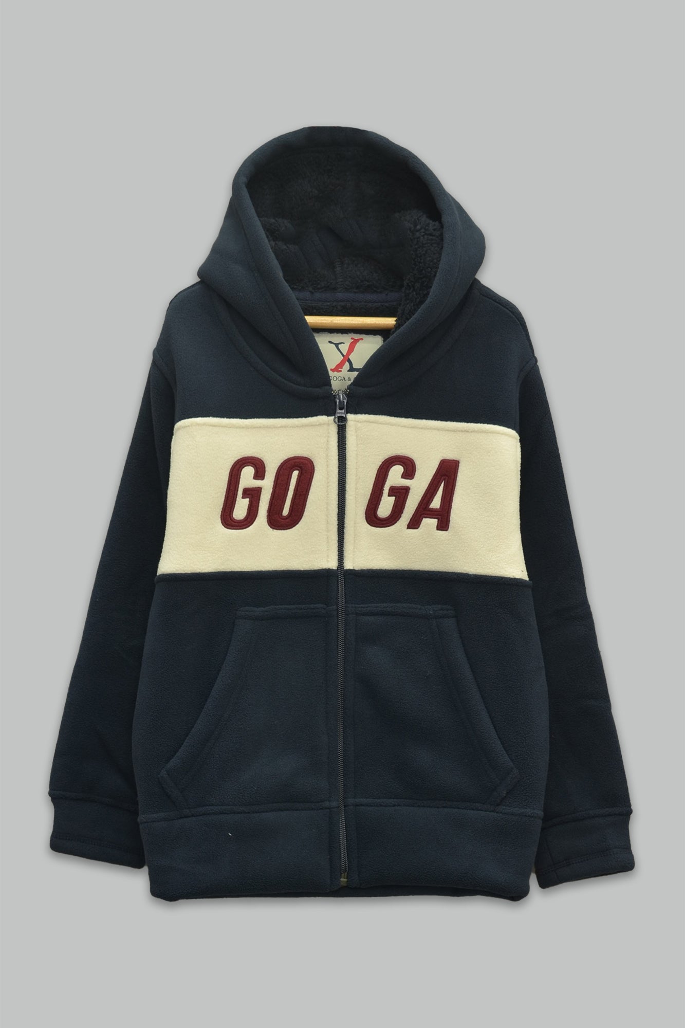 Sudadera sherpa niño bordada con manga larga, capucha ajustable, bolsas frontales y cierre.