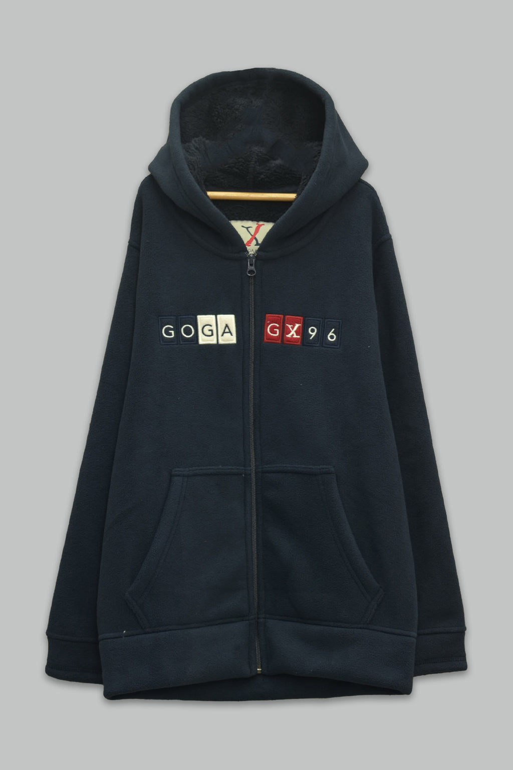 Sudadera sherpa niño bordada con manga larga, capucha ajustable, bolsas frontales y cierre.