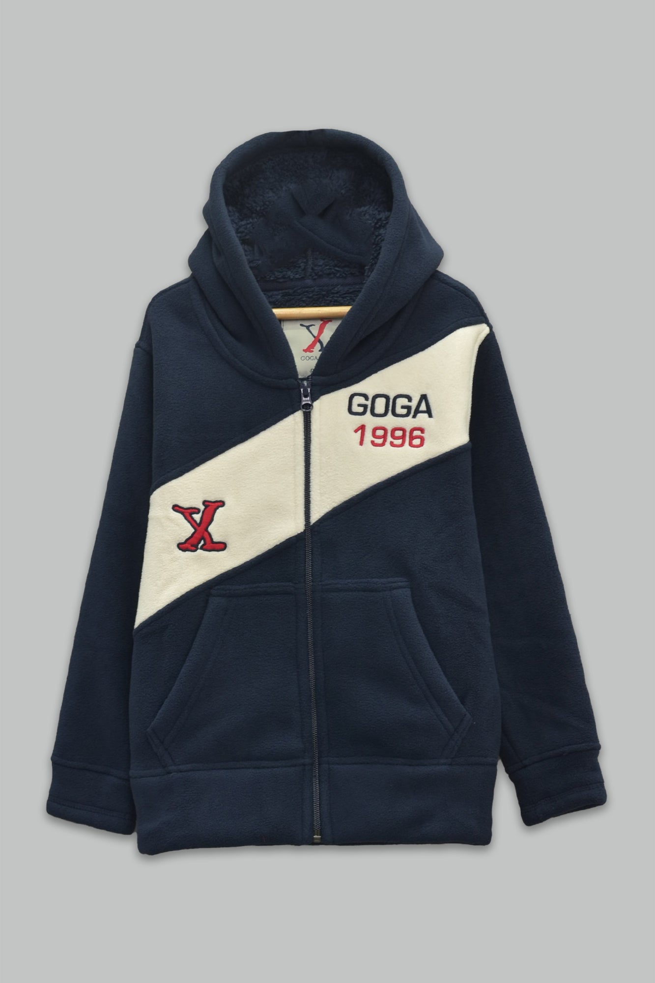 Sudadera sherpa niño bordada con manga larga, capucha ajustable, bolsas frontales y cierre.