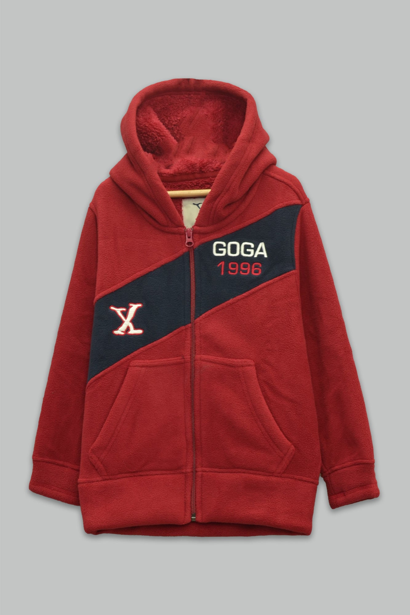 Sudadera sherpa niño bordada con manga larga, capucha ajustable, bolsas frontales y cierre.