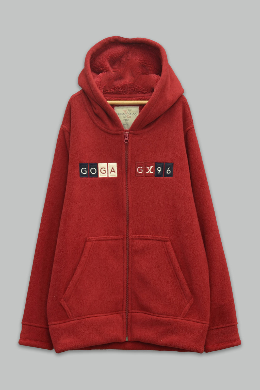 Sudadera sherpa niño bordada con manga larga, capucha ajustable, bolsas frontales y cierre.