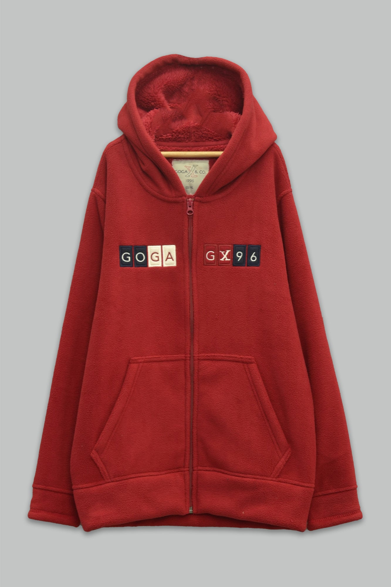 Sudadera sherpa niño bordada con manga larga, capucha ajustable, bolsas frontales y cierre.