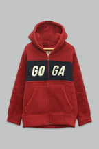 Sudadera sherpa niño bordada con manga larga, capucha ajustable, bolsas frontales y cierre.
