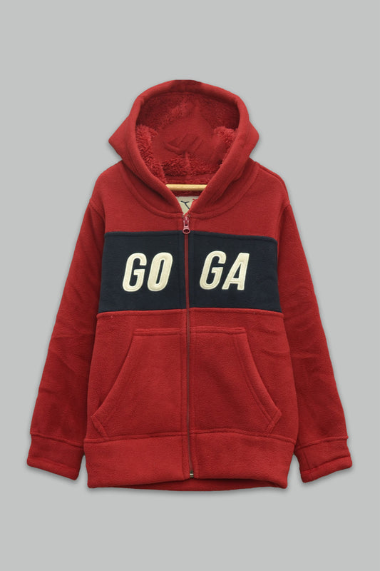 Sudadera sherpa niño bordada con manga larga, capucha ajustable, bolsas frontales y cierre.